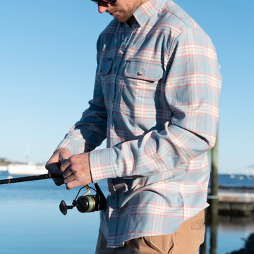 man fishing in blue and orange plaid flannel
