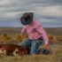 Man roping cattle in a pink corduroy shirt
