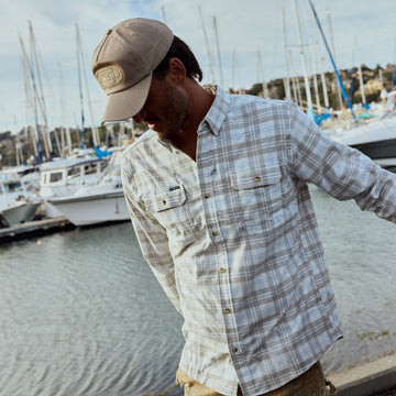 The Snowcat plaid shirt worn by a man beside boats at a marina