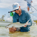 Man wearing blue long sleeve shirt holding bonefish