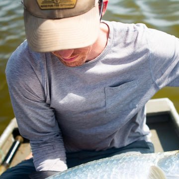 man with fish wearing grey crew