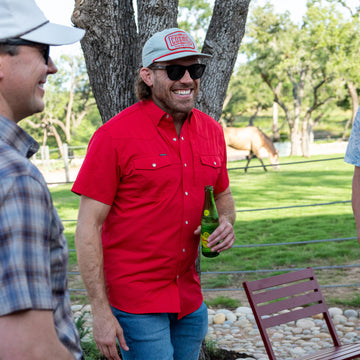 man smiling wearing short sleeve red shirt