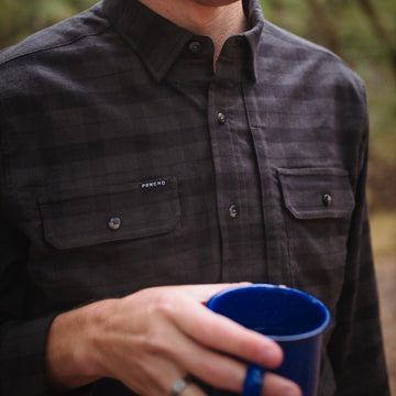 man holding coffee cup in black and grey plaid flannel