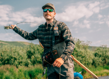 Man in green plaid shirt casting fly rod