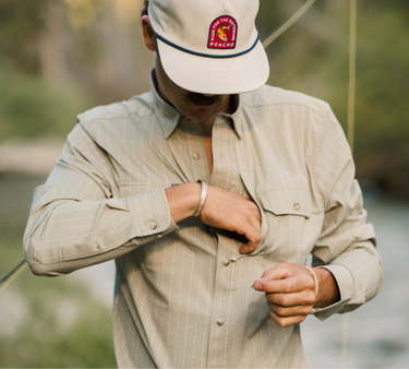 Man in tan shirt reaching n zipper pocket