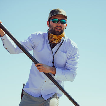 man pushing boat in blue microcheck long sleeve