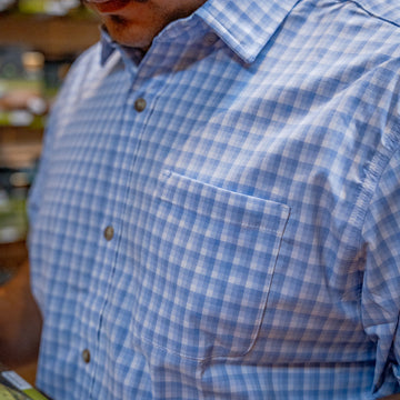 man reading in blue check shirt