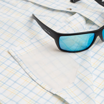 Sunglasses sitting on blue and yellow button down shirt hidden sunglass cleaner