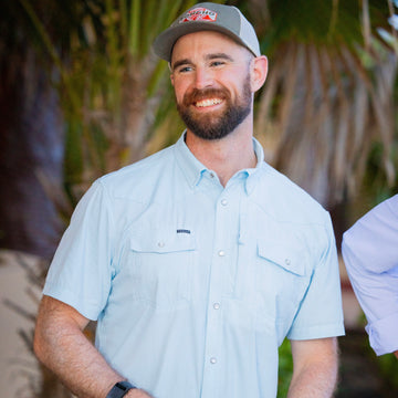 man smiling wearing blue short sleeve shirt