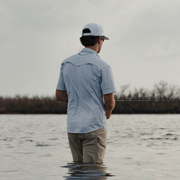 man facing away from camera wearing grey checkered shirt
