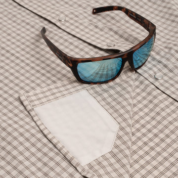 close up of sunglass cleaner on brown plaid shirt