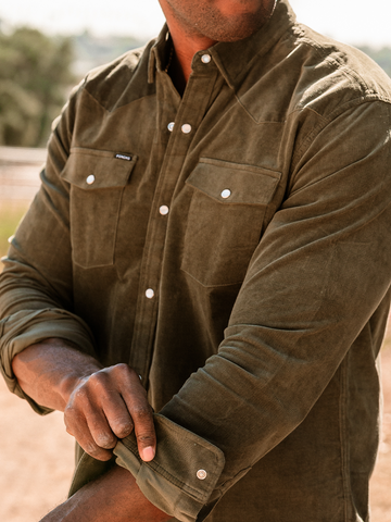 Man in green shirt rolling up sleeve