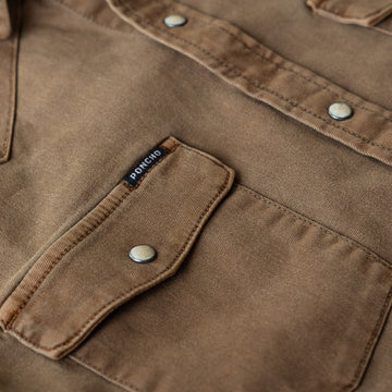 Detail shot of pocket of brown denim shirt