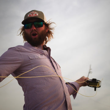 man fishing with maroon long sleeve shirt