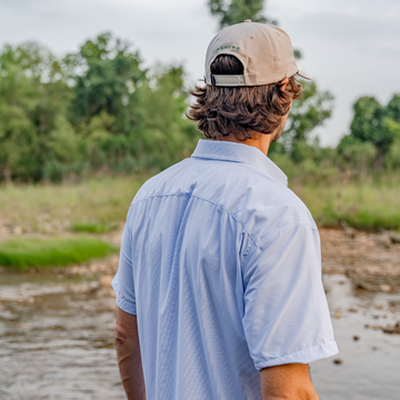 back of blue micro check shirt on river