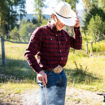 man building a fire in red and black flannel