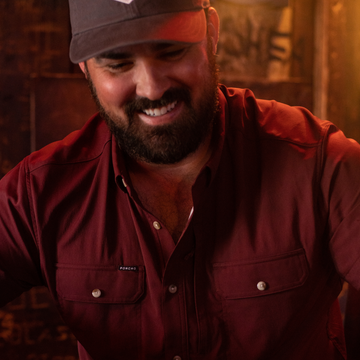 man smiling wearing maroon shirt