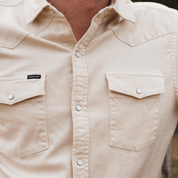 Close up of man wearing white denim shirt