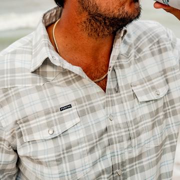 Close up photo of man wearing blue and grey plaid flannel