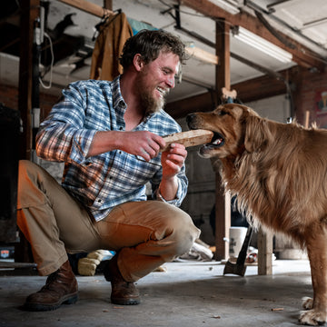 man with dog in blue plaid flannel shirt