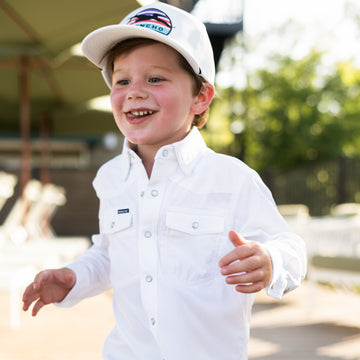 closeup of young kid in white pearl snap shirt.