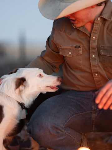 man with dog wearing brown denim shirt