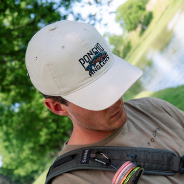 Man wearing Poncho fishing dad hat while fishing