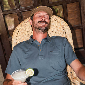 man with beverage wearing blue polo shirt