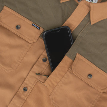 phone in pocket of brown and green shirt