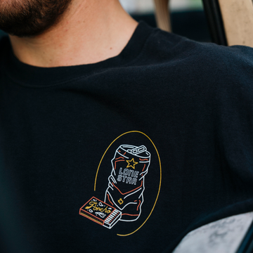The Dive T-Shirt in black featuring an illustrated Lone Star beverage can and snack graphic