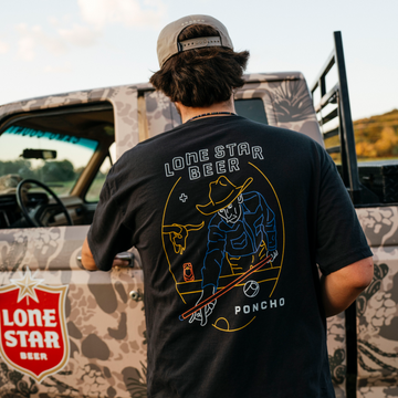 The Dive T-Shirt shown from behind with a colorful cowboy graphic beside a camouflaged vehicle