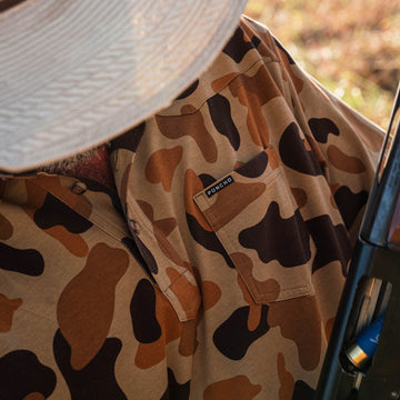 man with shotgun wearing camo polo shirt