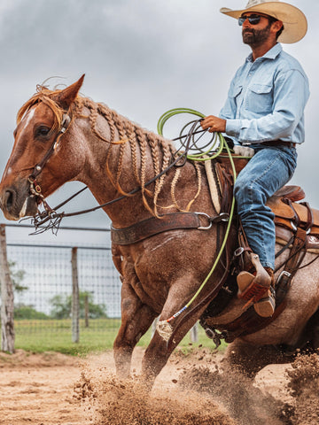 cowboy riding horse in denim shirt