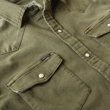 Detail shot of pocket on green denim shirt