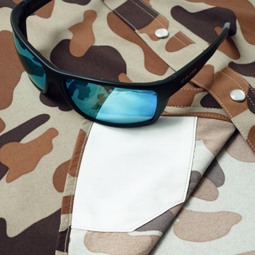 sunglasses with lens cleaner on camo shirt