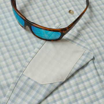 sunglasses and lens cleaner on shirt