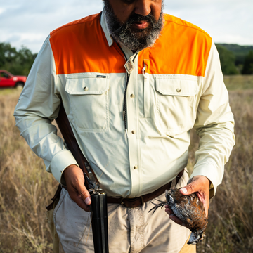 man holding bird wearing long sleeve tan blaze patch shirt