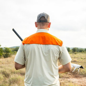 man with gun wearing tan blaze patch short sleeve shirt