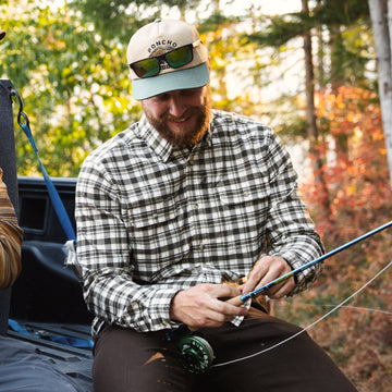 man holding fishing rod wearing the copperhead flannel