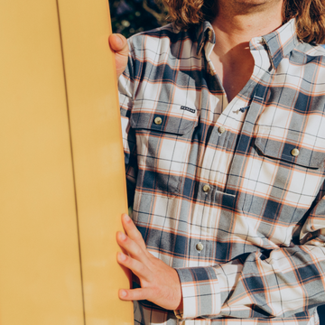 man with surfboard wearing the half moon shirt
