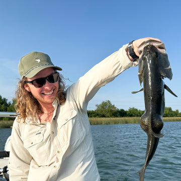 man with fish wearing green mallard rope hat