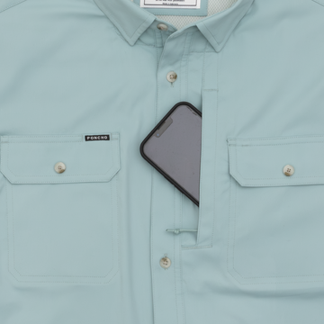 phone in pocket of light blue long sleeve fishing shirt
