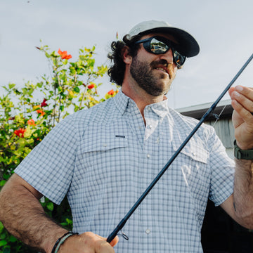 Man rigging up fly rod on the beach