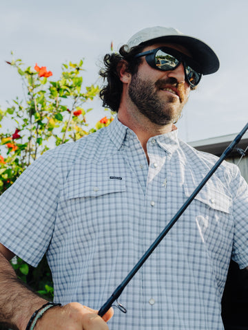 Man rigging up fly rod on the beach