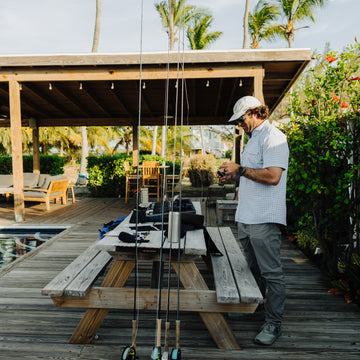 Man rigging up fly lines by a pool in the bahamas