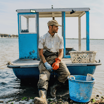 Man wearing short sleeve button down green plaid sitting on boat