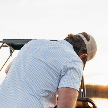 back of blue and grey shirt on man fishing