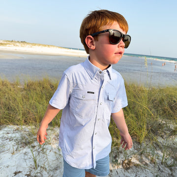 kid on the beach wearing blue pearl snap short sleeve shirt