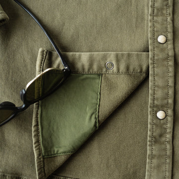 Detail shot of lens cleaning cloth on green denim shirt