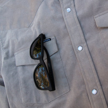 Detail shot of sunglasses on grey corduroy shirt